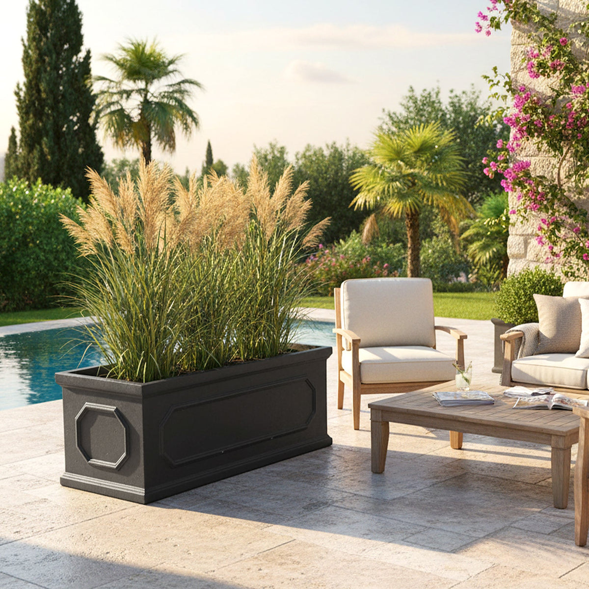 Trough planter with pampas grasses on a stone patio beside garden chairs