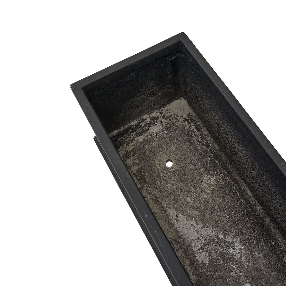 Inside of the empty cement trough showing the drainage hole in the base