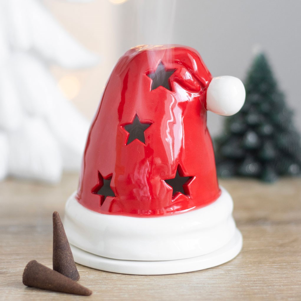 Santa hat holder used as an incense burner with smoke rising, two incense cones in front