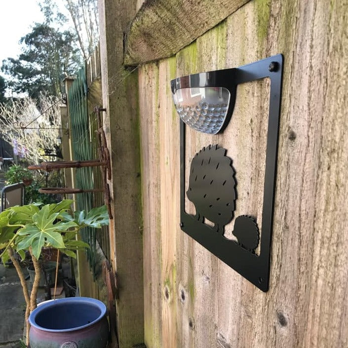 Side view of the hedgehog solar plaque fixed to a garden fence