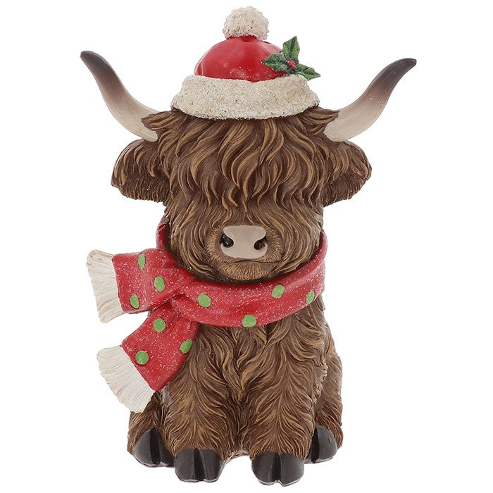 Sitting Highland Cow figure in a red Santa hat and a red scarf with green dots on white