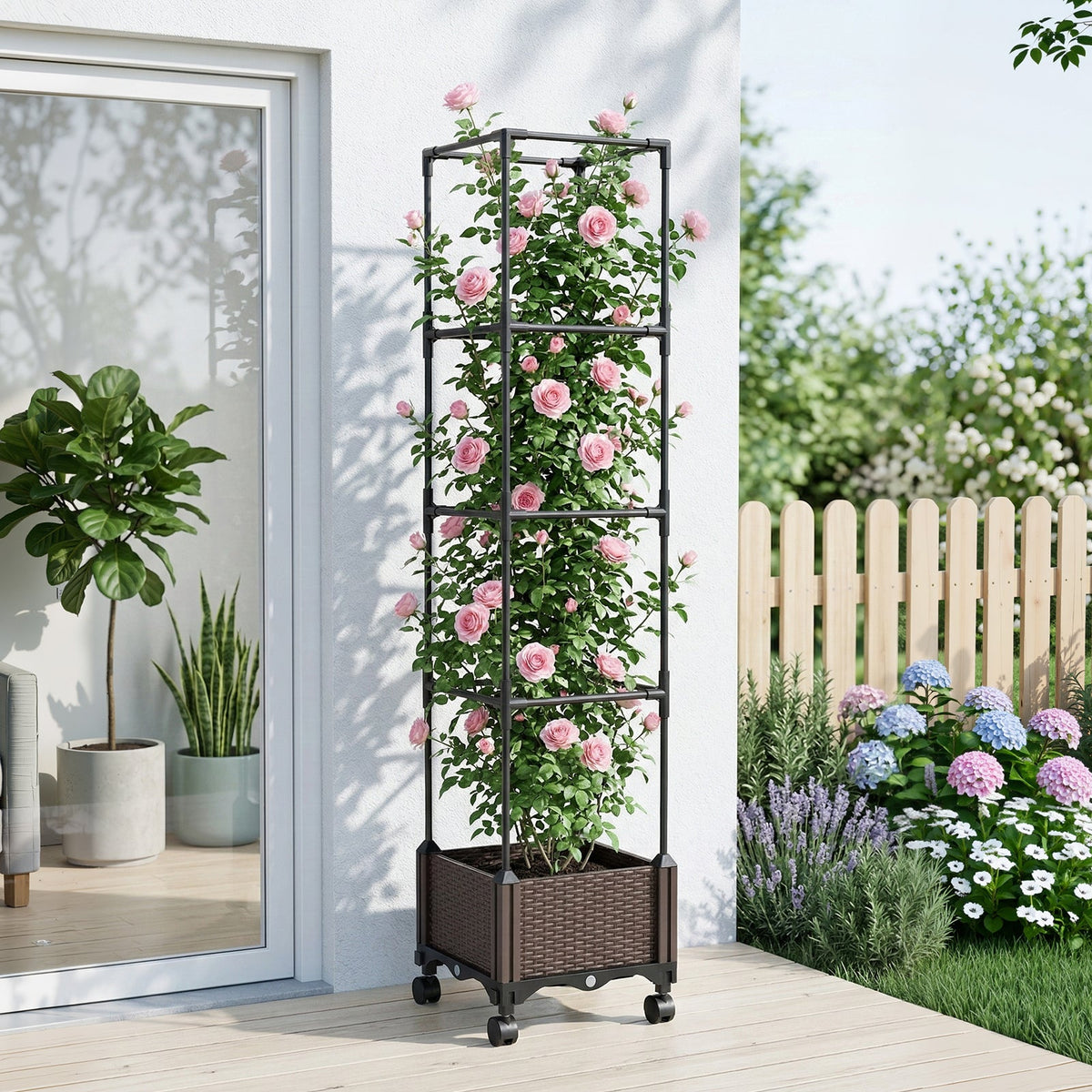 Planter with trellis covered in pink climbing roses on a patio beside glass doors