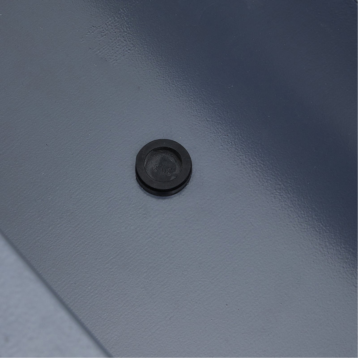 Close-up of the black rubber plug in the planter's drainage hole