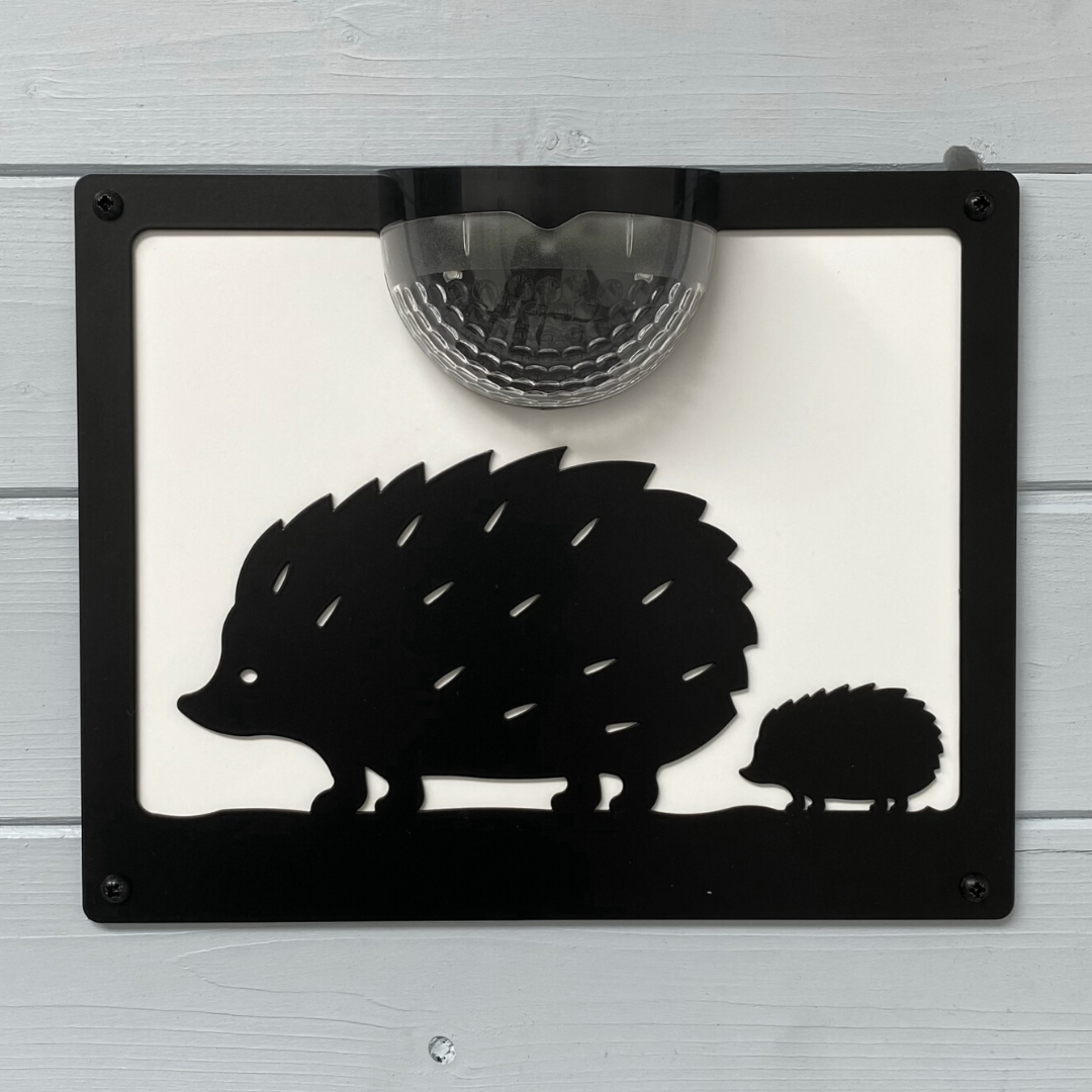 Hedgehog solar wall plaque with white backing panel on white wooden cladding