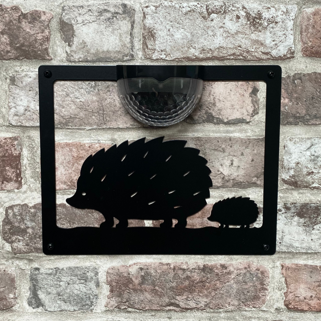 Open hedgehog cut-out solar plaque without backing panel on a brick wall