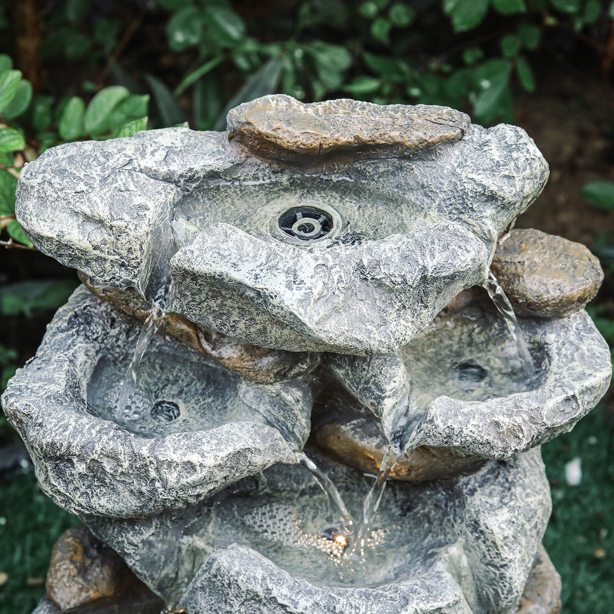 Top of the fountain showing the water outlet and the rock bowls below