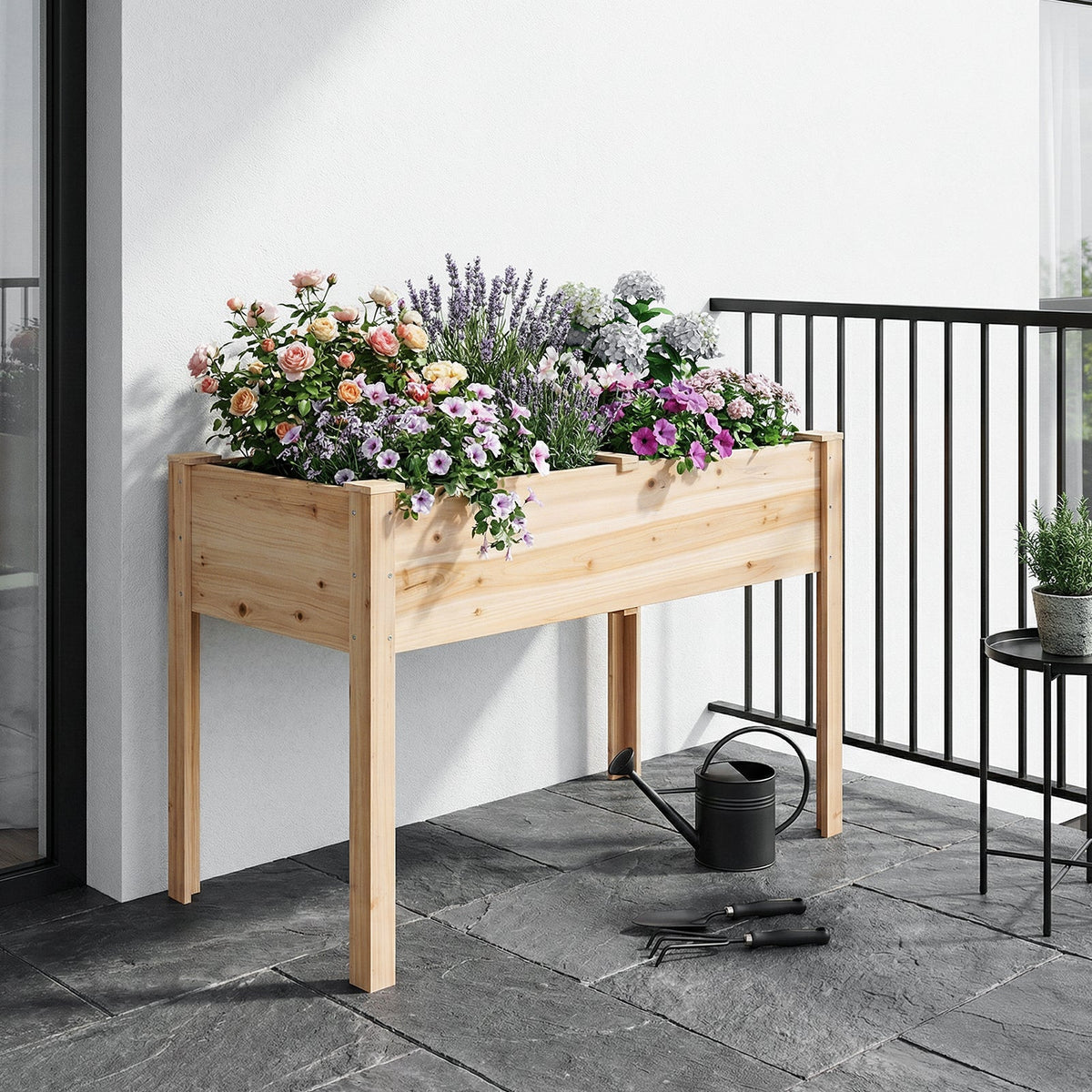 Natural raised bed on legs with pink flowers and lavender on a balcony