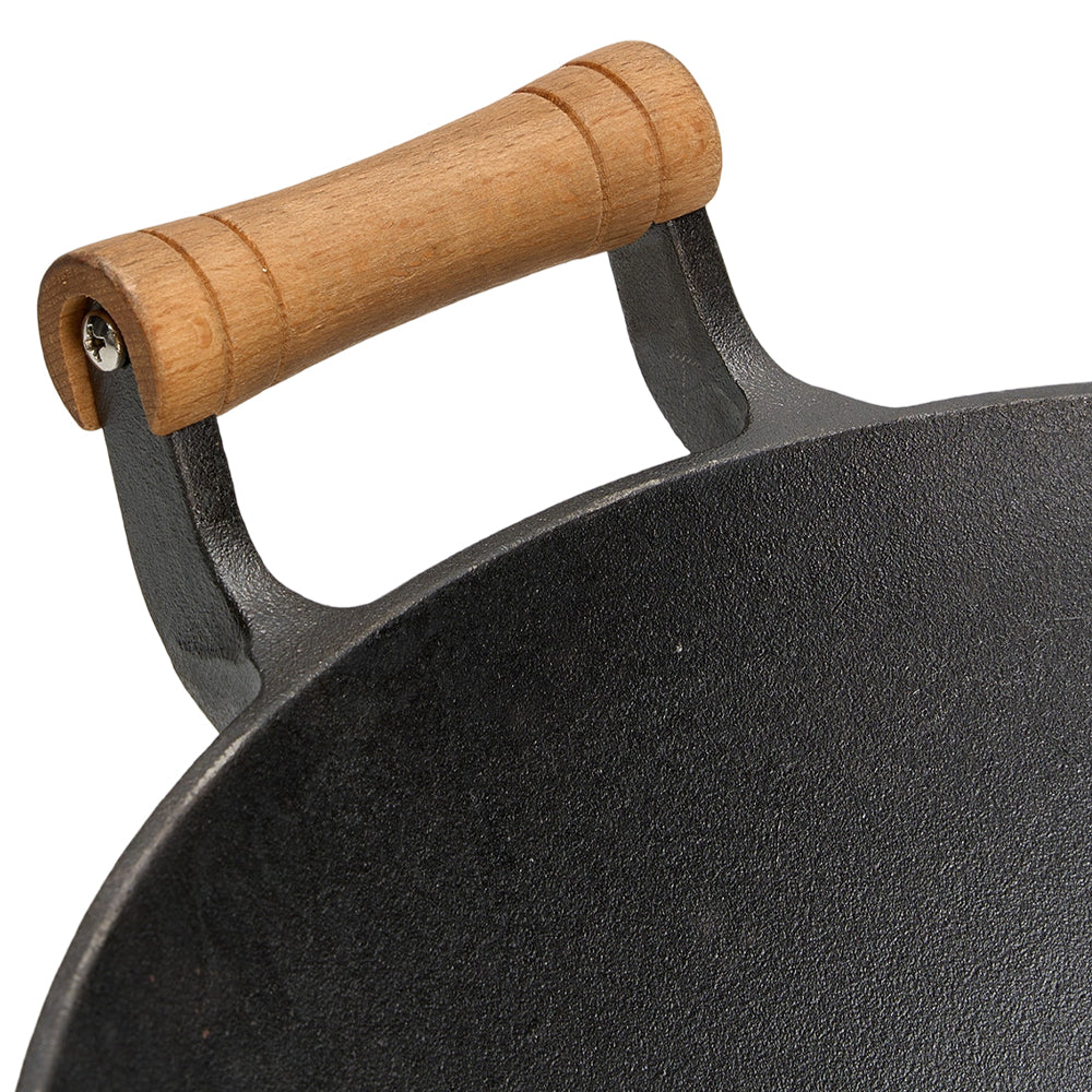 Close-up of a wooden handle sleeve on its cast iron bracket at the wok's rim