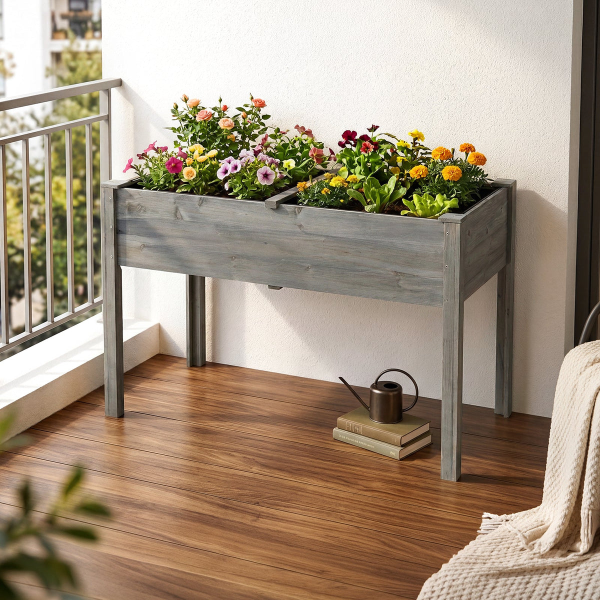Grey wooden raised bed with bright flowers on a balcony with a wooden floor
