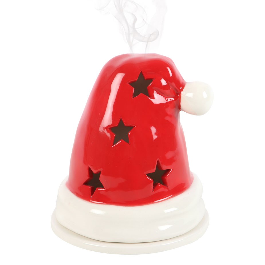 Red Santa hat incense holder with star cut-outs and smoke rising from the top, on white