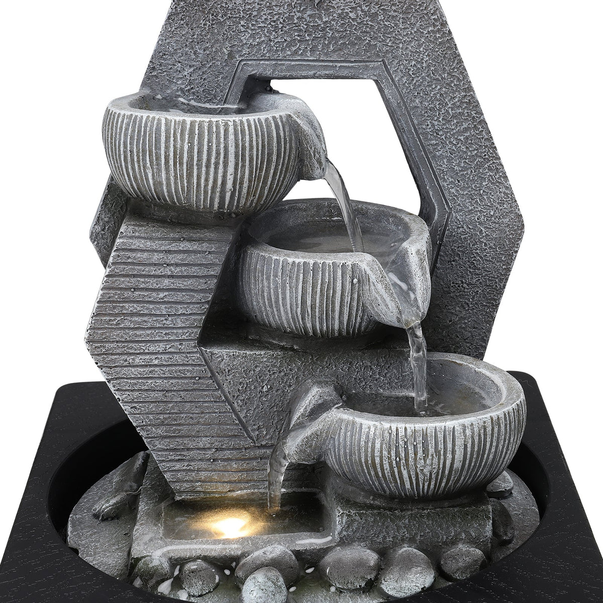 Close-up of water falling from the ribbed bowls with the LED glowing below