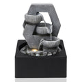 Grey resin tabletop fountain with three ribbed bowls in a hexagonal frame on a square black basin