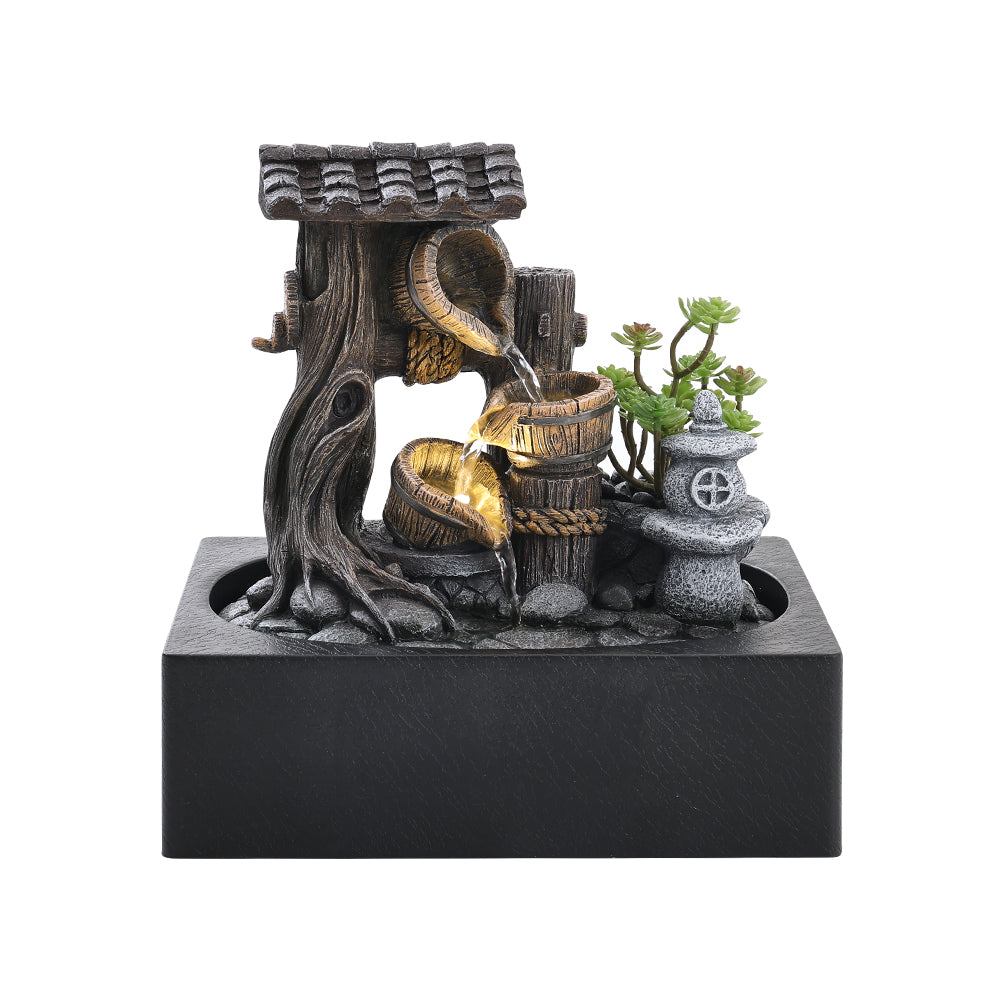 Resin tabletop fountain with a tiled roof, tree trunk, two buckets and a stone lantern on a dark basin