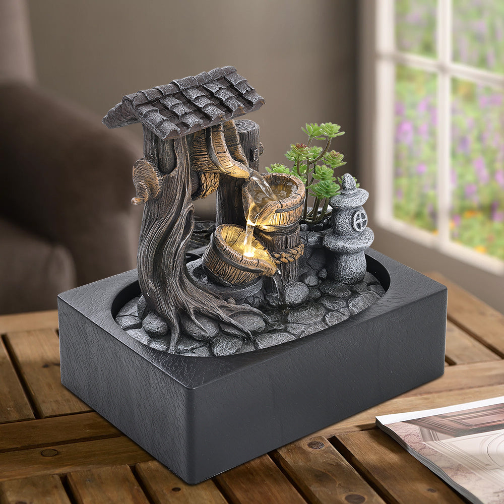 Tabletop water fountain on a wooden table by a window
