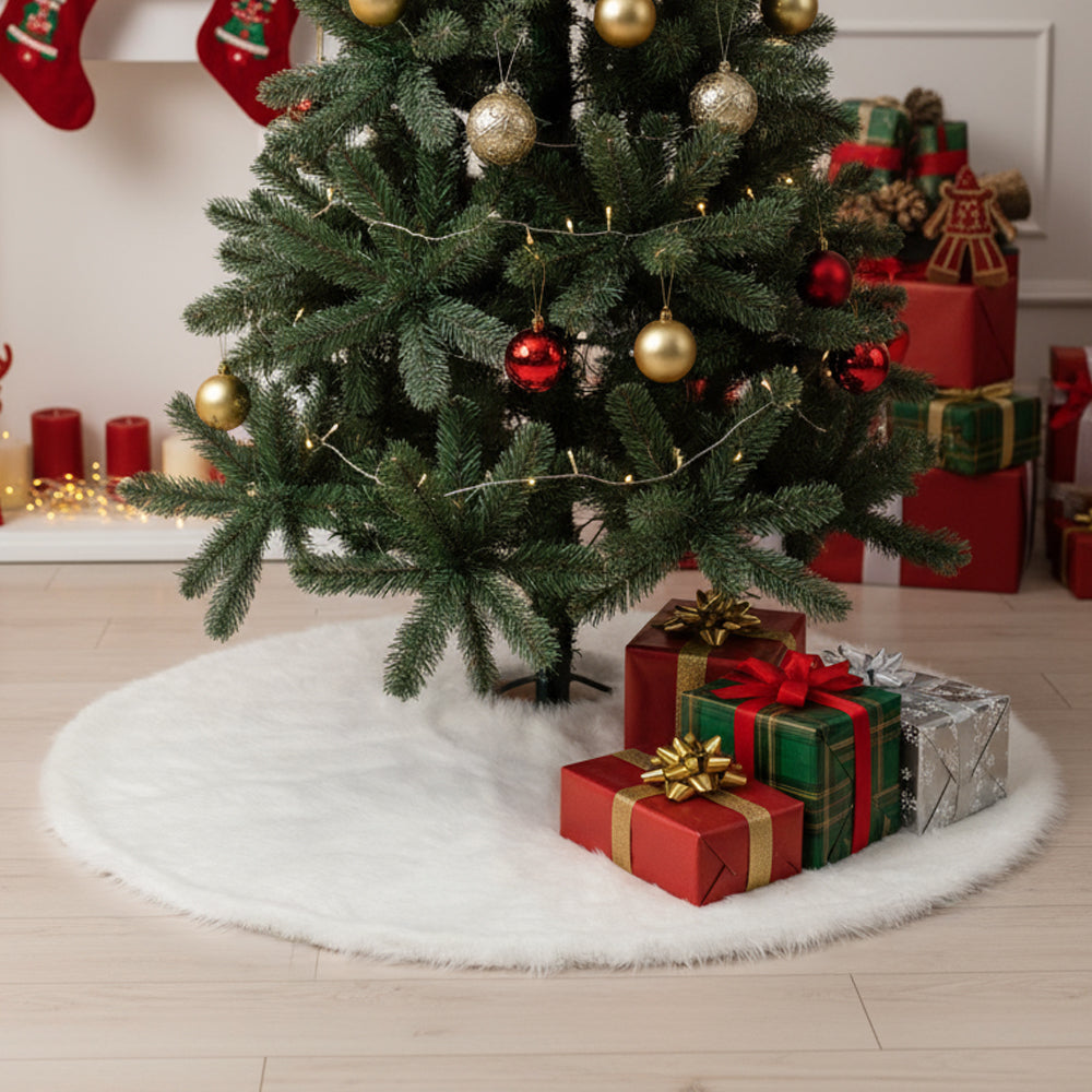 White plush tree skirt under a green Christmas tree with red and green presents