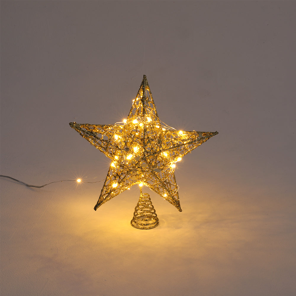 Gold star topper lit by its LED light string, standing on its spiral base