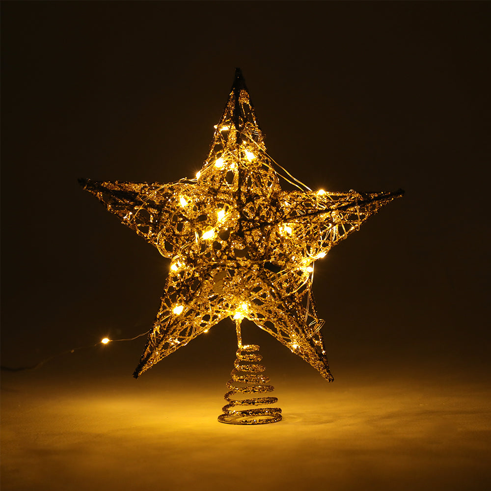 Gold star topper glowing with its LED lights in a dark room