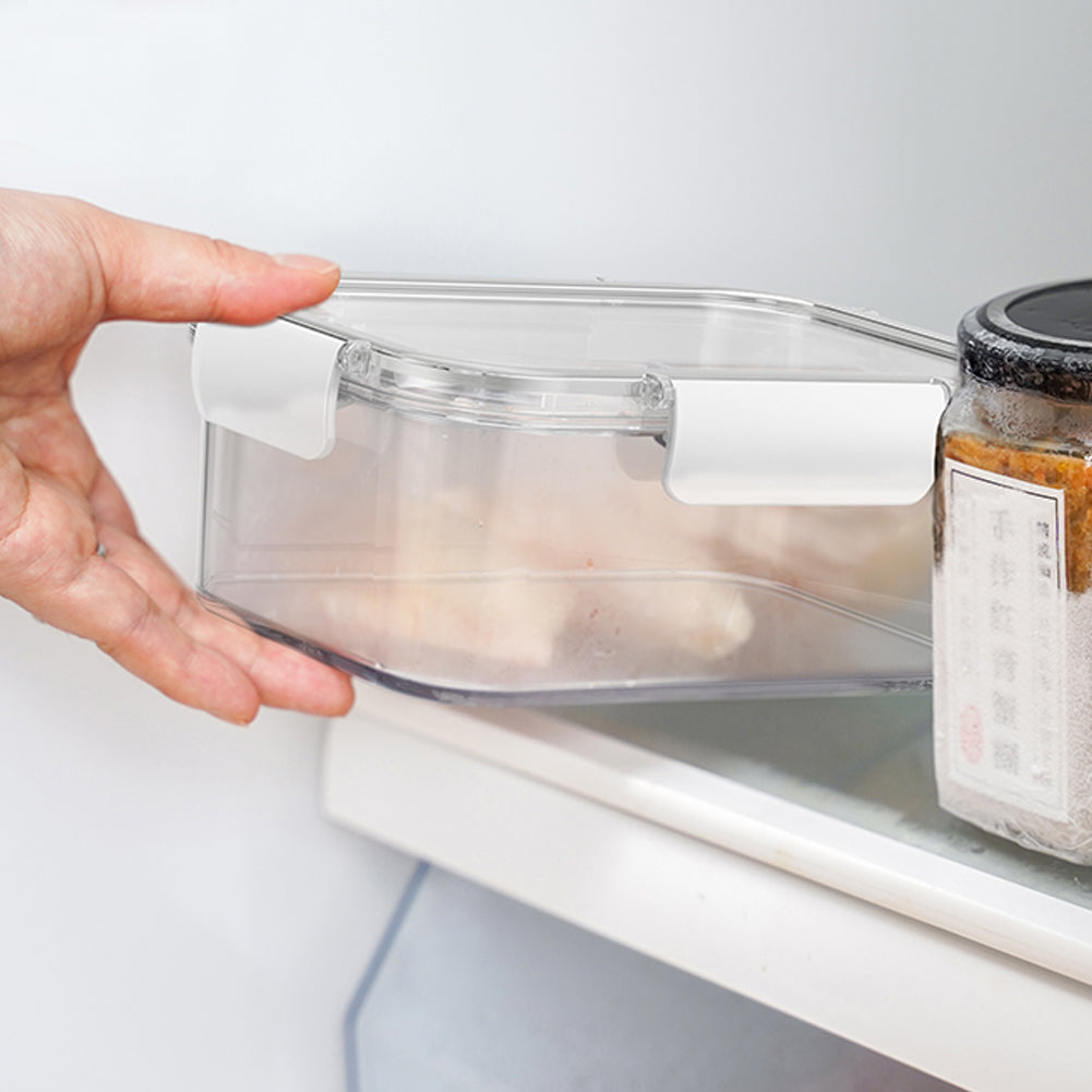 A hand sliding a clear clip-lid box onto a fridge shelf