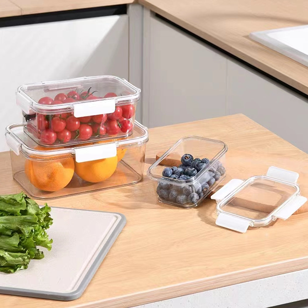 Three clear boxes holding cherry tomatoes, oranges and blueberries on a kitchen worktop