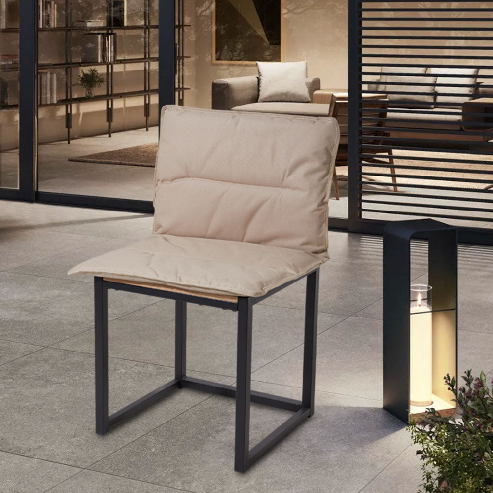 Khaki one-piece seat and back cushion on a black metal chair on a paved terrace