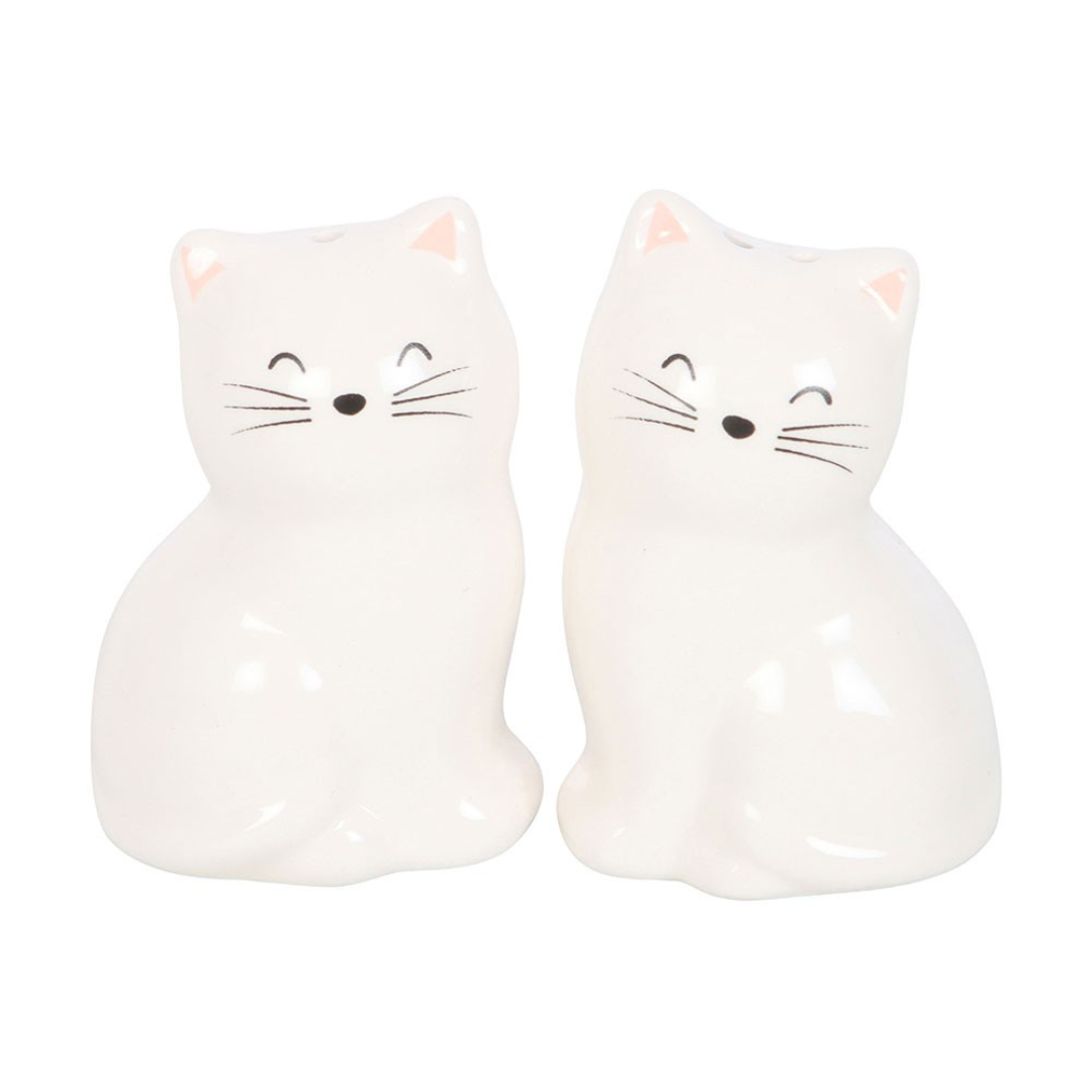 Two white ceramic sitting-cat shakers with painted smiling faces and whiskers on white