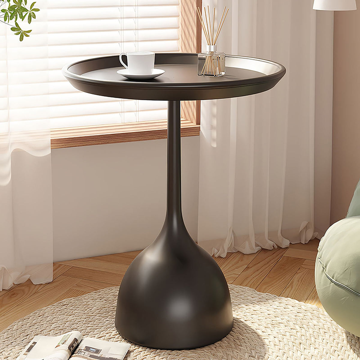 Black round side table beside a sofa in a bright living room