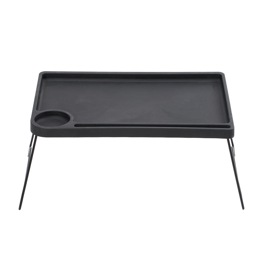 Black folding bed table with a cup holder and tablet groove on white