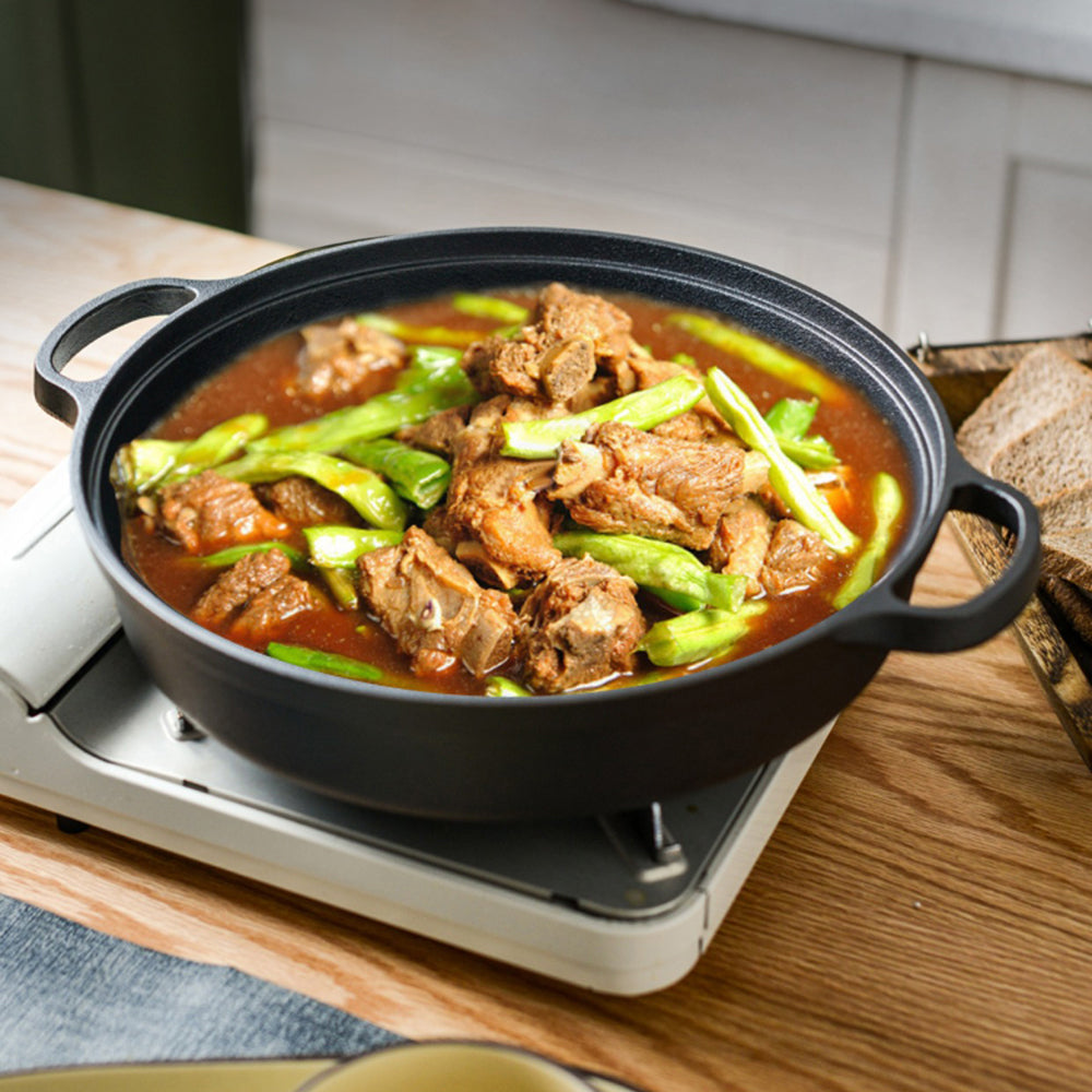 Braised meat and green peppers in the cast iron braiser on an electric hotplate