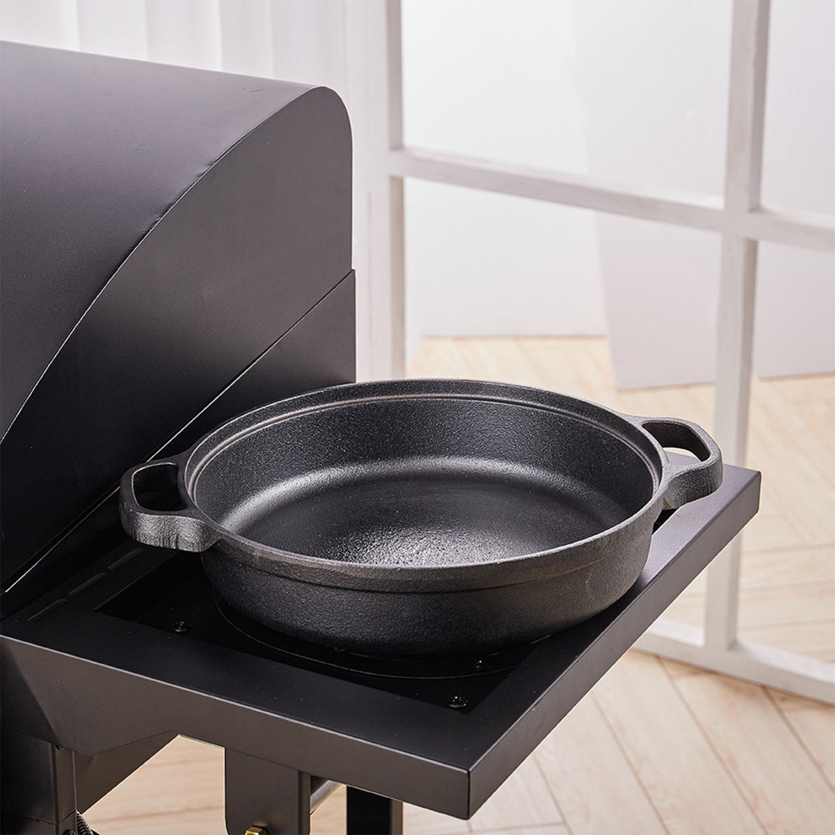 Empty cast iron skillet on the side burner of an outdoor grill