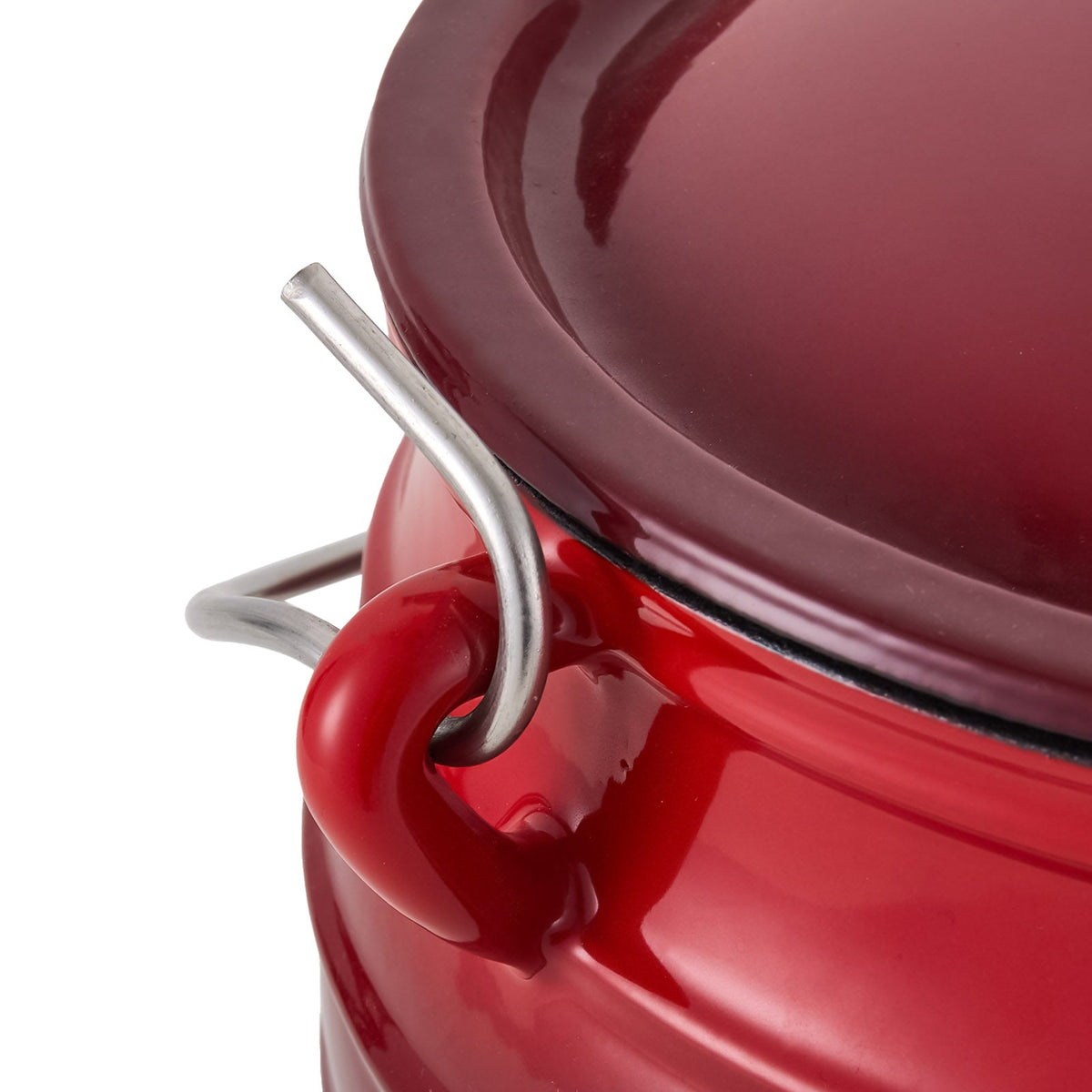 Close-up of the steel lifting handle hooked into the cast lug of the red cauldron