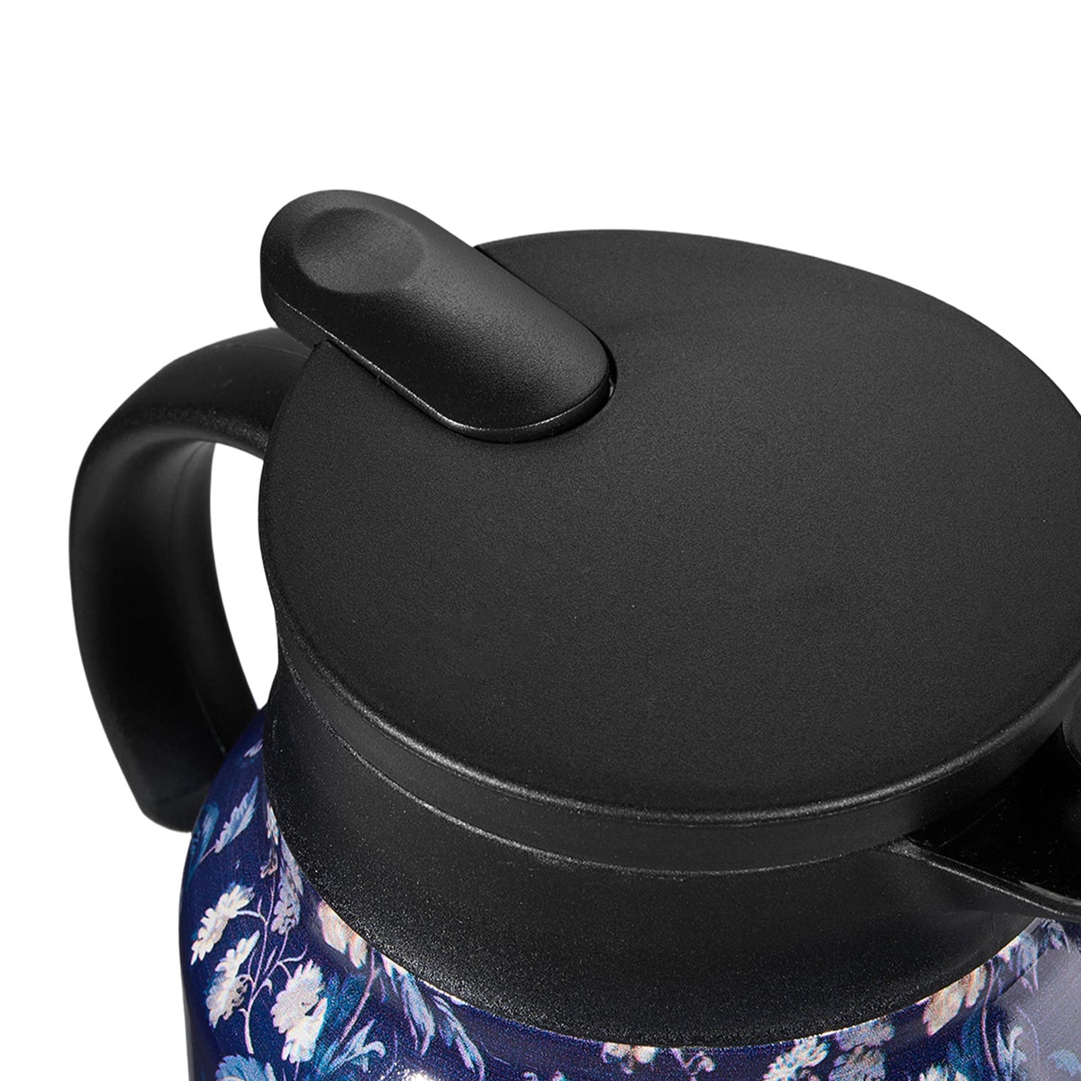 Close-up of the black lid with its press button and the handle of the navy floral teapot