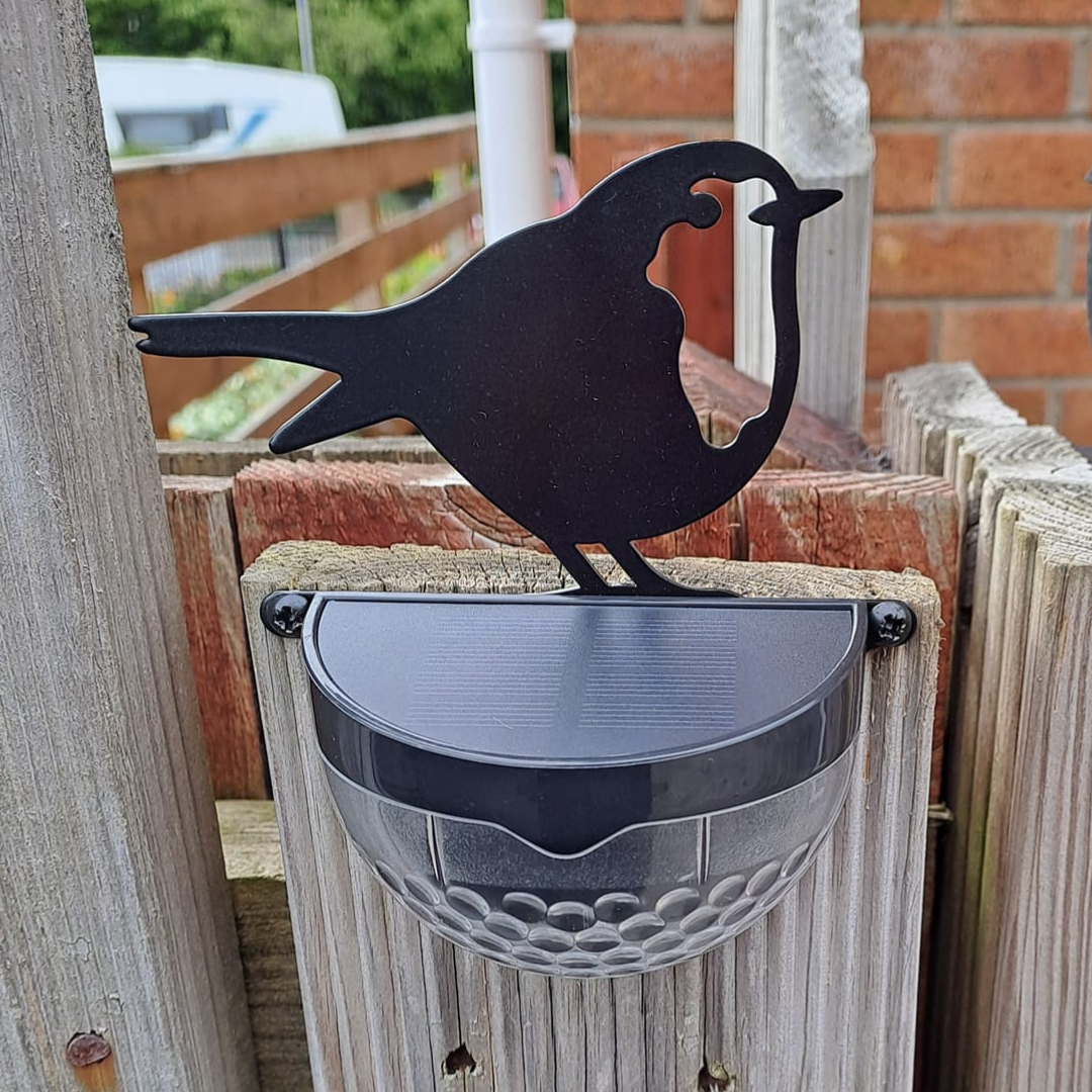 Robin solar light on a fence post, showing the solar panel on top of the lamp