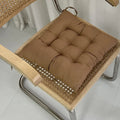 Brown tufted square seat cushion on a cane-seat chair with a chrome frame