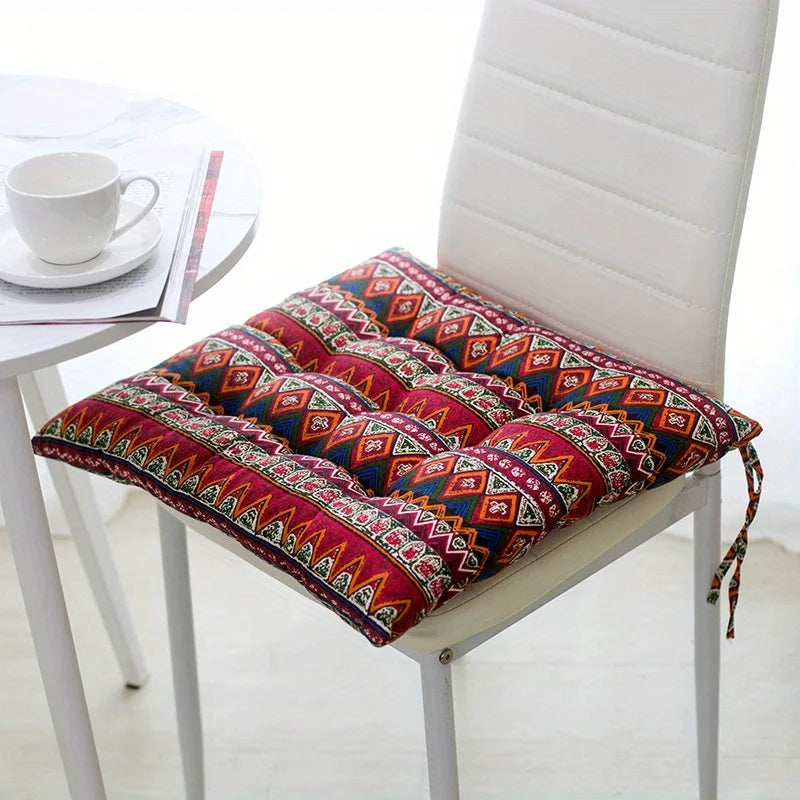 Red geometric-print square tufted cushion tied onto a white dining chair