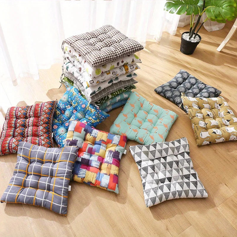 An assortment of square tufted seat cushions in several prints laid out on a wooden floor