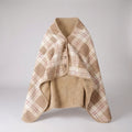 Beige and red plaid wearable throw with beige fleece lining, buttoned at the front, on a pale background