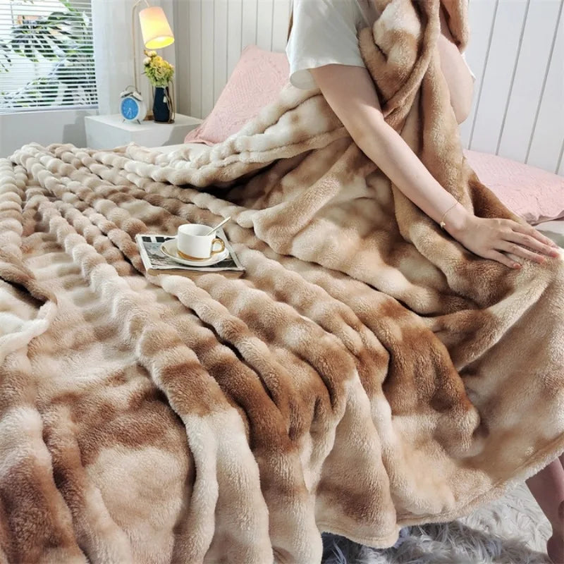 The light brown and cream striped plush blanket spread over a bed
