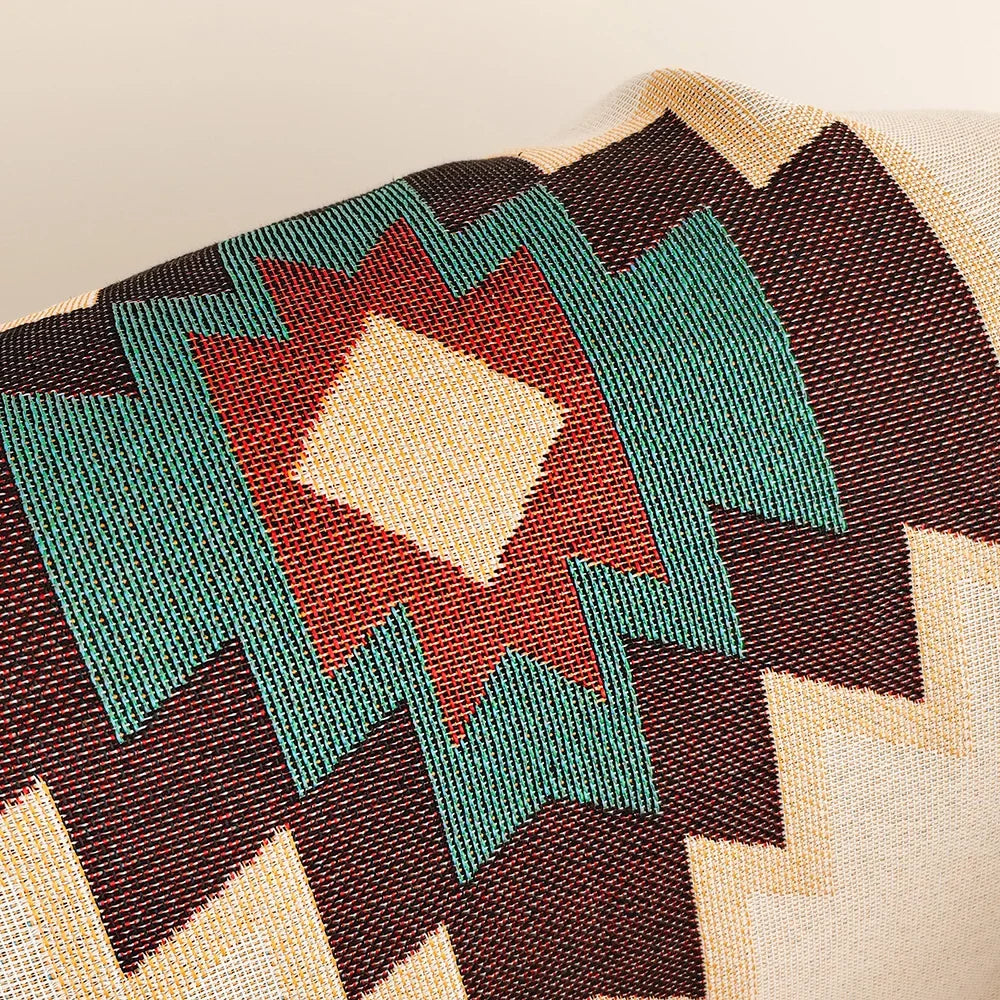 Close-up of the woven diamond motif in burgundy, teal and rust showing the jacquard texture