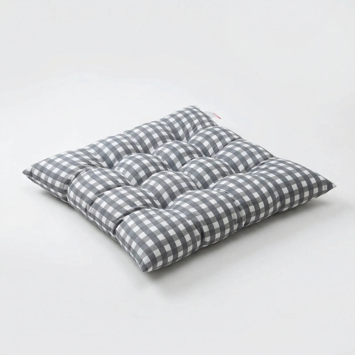 Light grey and white gingham tufted seat cushion on a white background