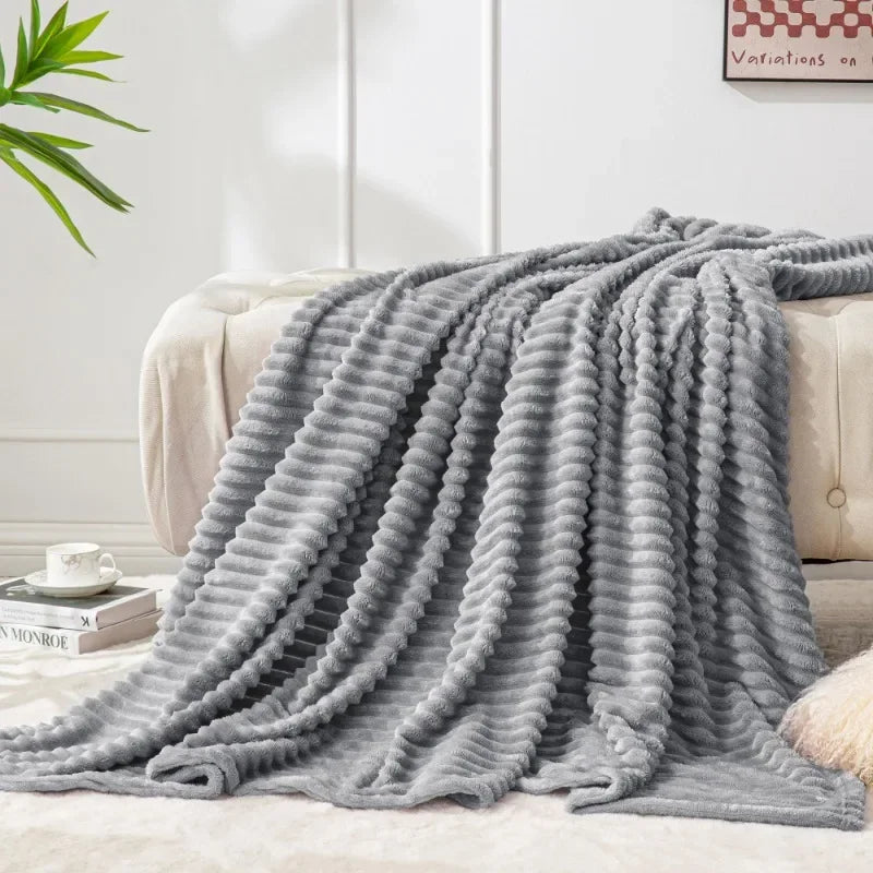 Light grey ribbed throw spread over a cream sofa and rug