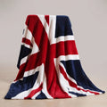 Union Jack plush throw blanket hanging open over a chair, showing the full red, white and navy flag print