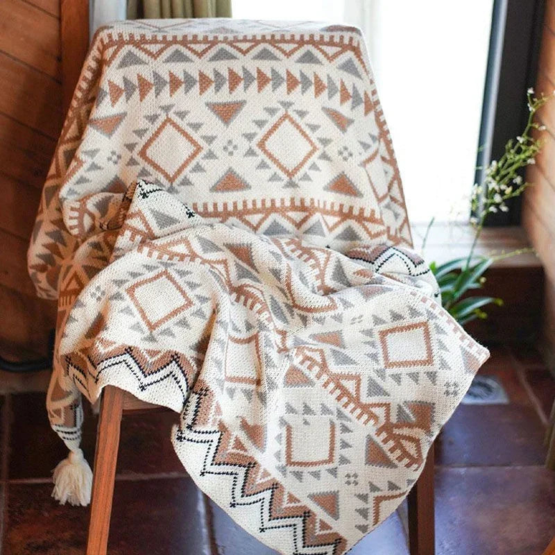 The geometric knitted throw draped over a wooden chair