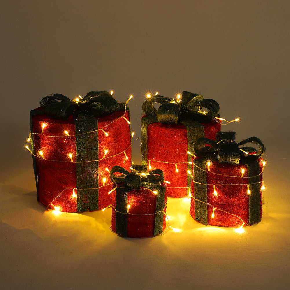 Four red sisal gift boxes with green ribbons grouped together, glowing with LED lights