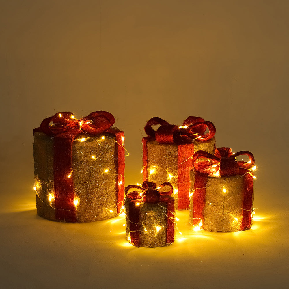 Four gold sisal gift boxes with red ribbons grouped together, glowing with LED lights