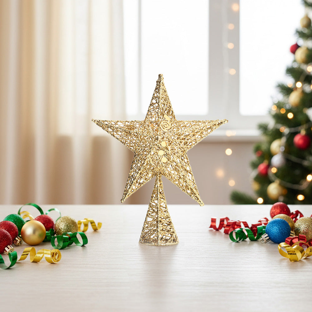 Gold glittered wire star tree topper standing on a table beside Christmas baubles