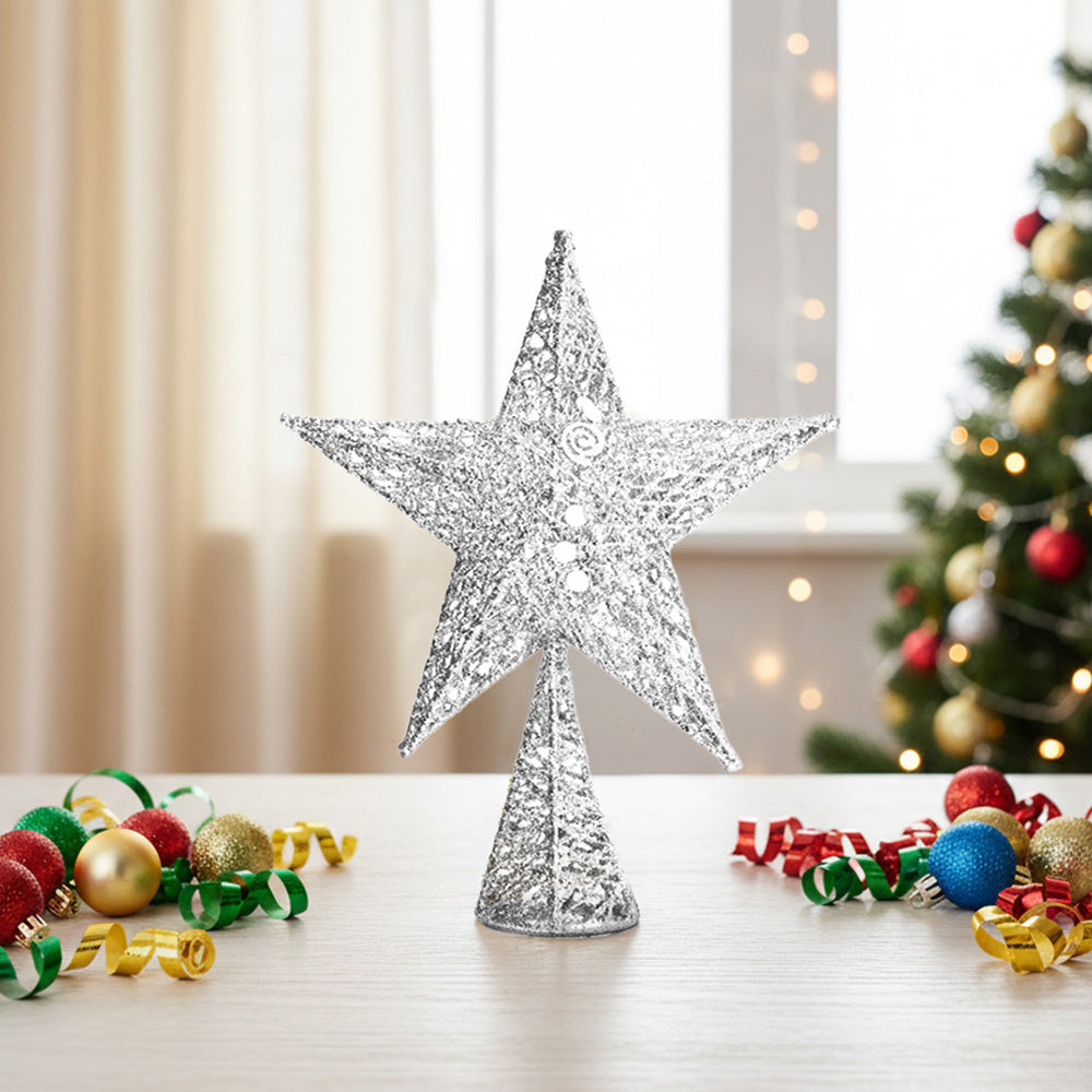 Silver glittered wire star tree topper standing on a table beside Christmas baubles