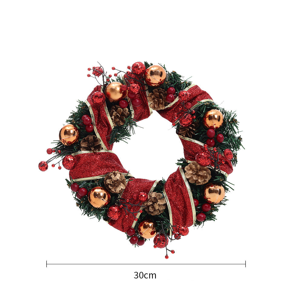 Red ribbon Christmas wreath with gold baubles, pine cones and red berries on white, marked 30 cm across