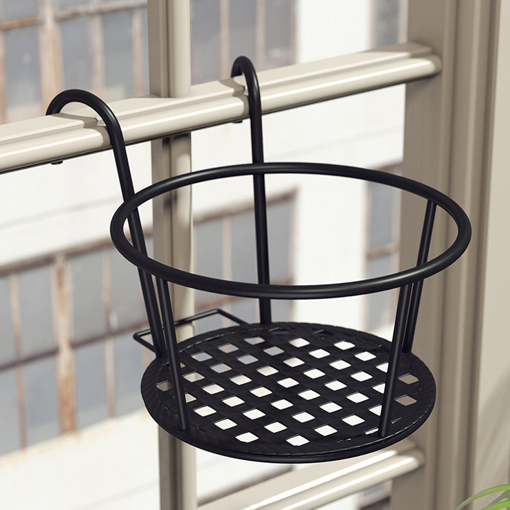 Empty black iron pot holder with two hooks hung over a balcony rail, latticed base showing
