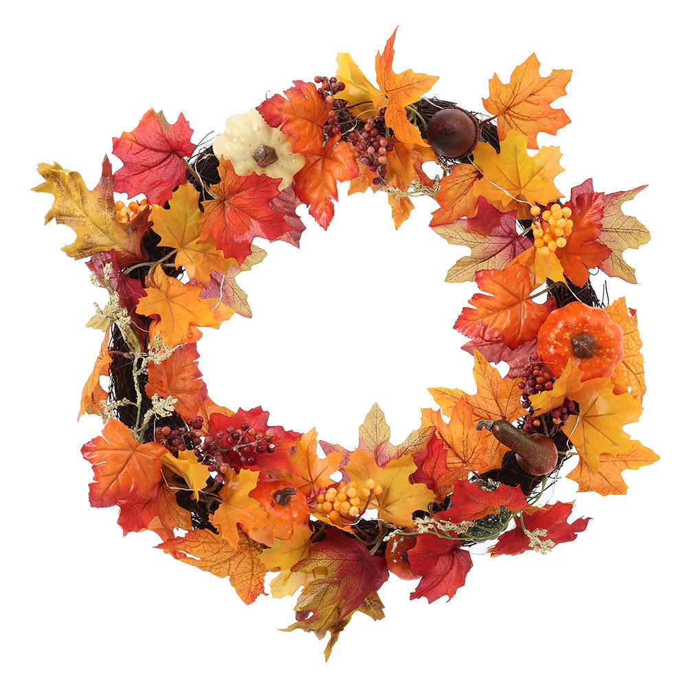 Autumn wreath of maple leaves, berries and small pumpkins on a woven branch ring on white