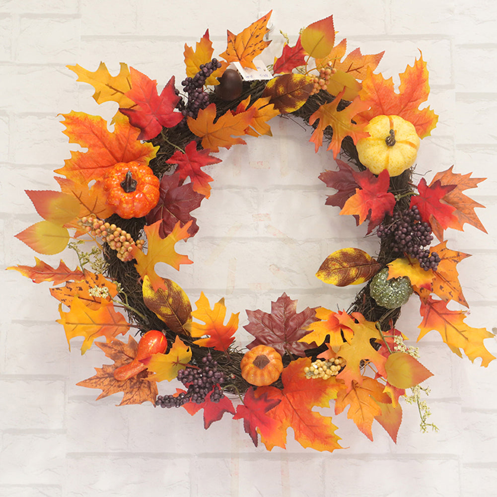 The autumn wreath on a white brick wall showing the woven branch ring between the leaves